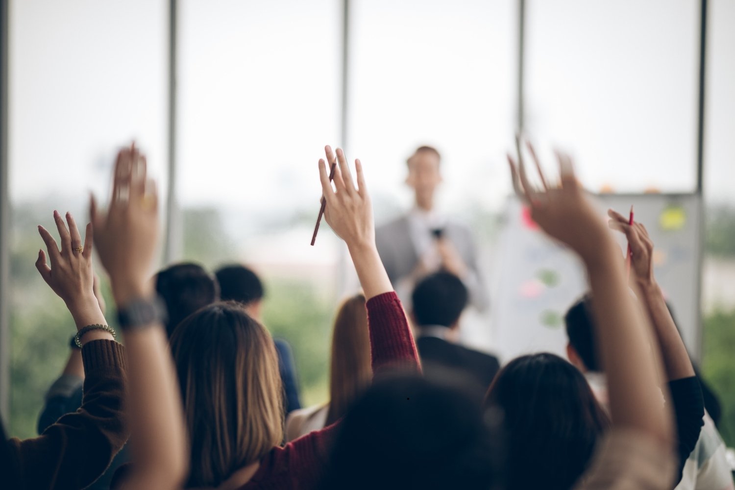 Participants raising hand at seminar