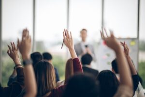 Participants raising hand at seminar